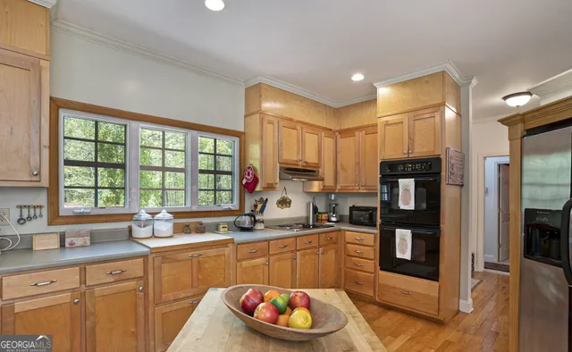 a kitchen with granite countertop a sink cabinets and wooden floor