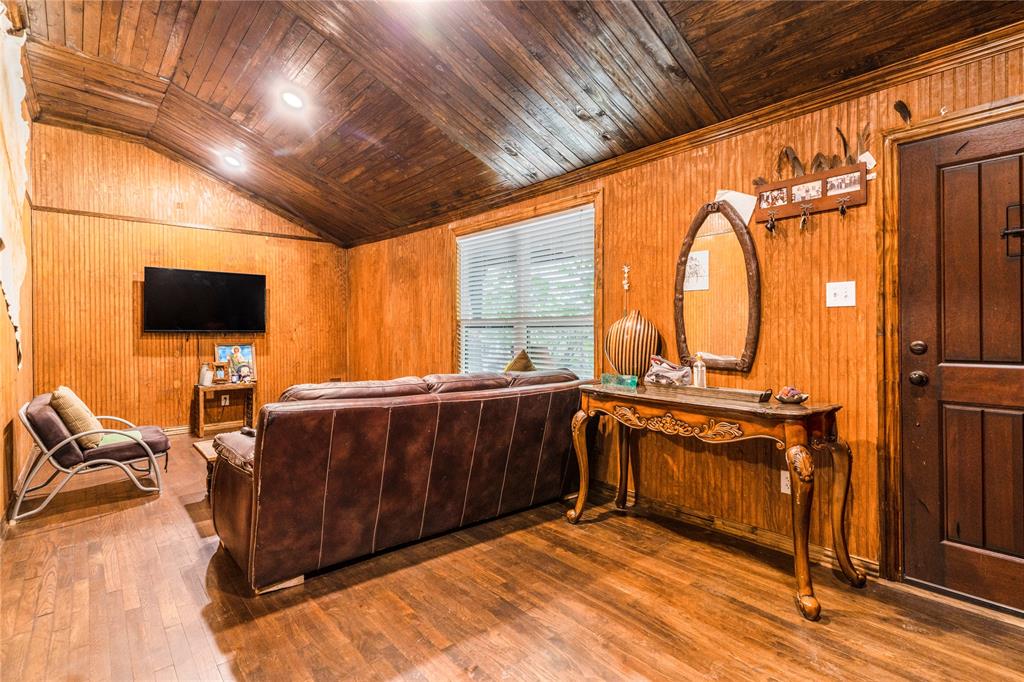 548 Elston Drive Dallas, TX 75232 - Photo 4 of 18 Living area featuring wood walls, hardwood / wood-style flooring, vaulted ceiling, and wood ceiling