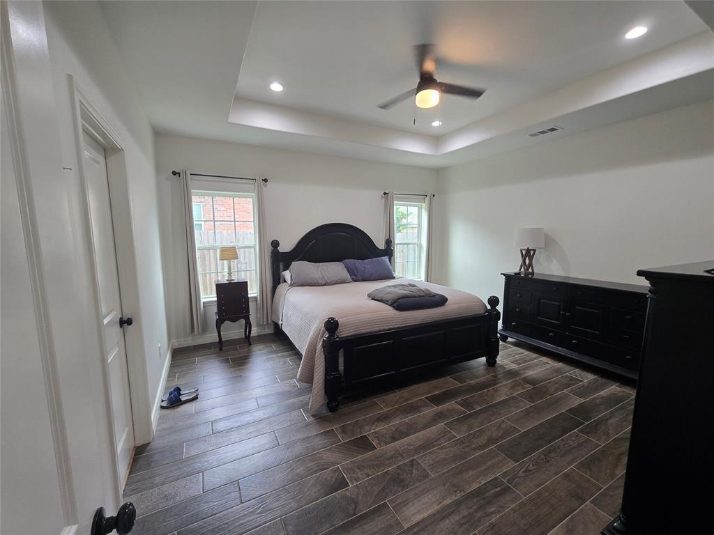 109 Baker Street Mount Vernon, TX 75457 - Photo 11 of 20 a bedroom with a bed and a chandelier