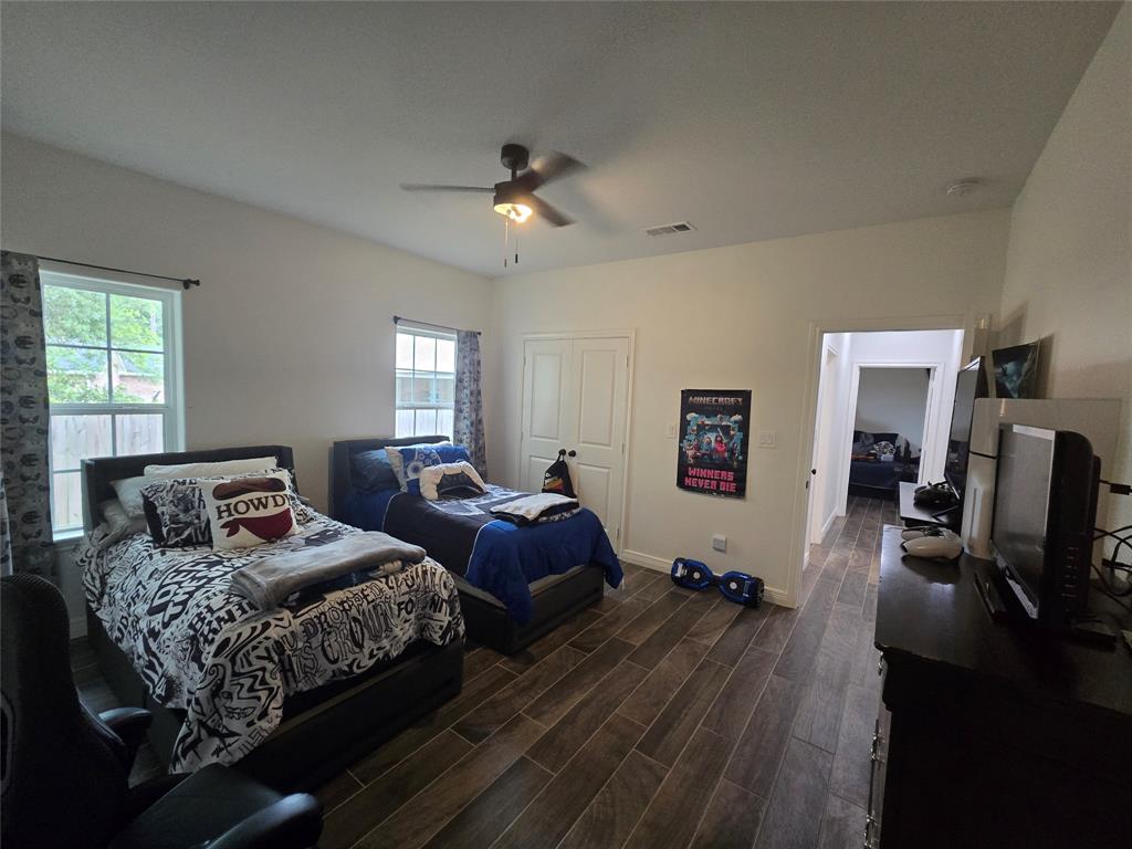 109 Baker Street Mount Vernon, TX 75457 - Photo 13 of 20 a bedroom with two beds and a chandelier