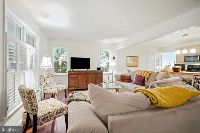 a living room with fireplace a table and a flat screen tv