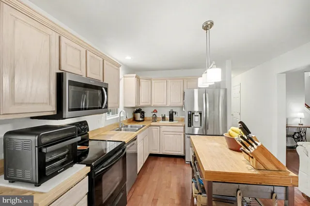 a kitchen with stainless steel appliances a stove a sink and white cabinets