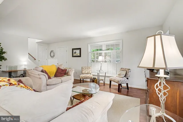 a living room with furniture kitchen view and a flat screen tv
