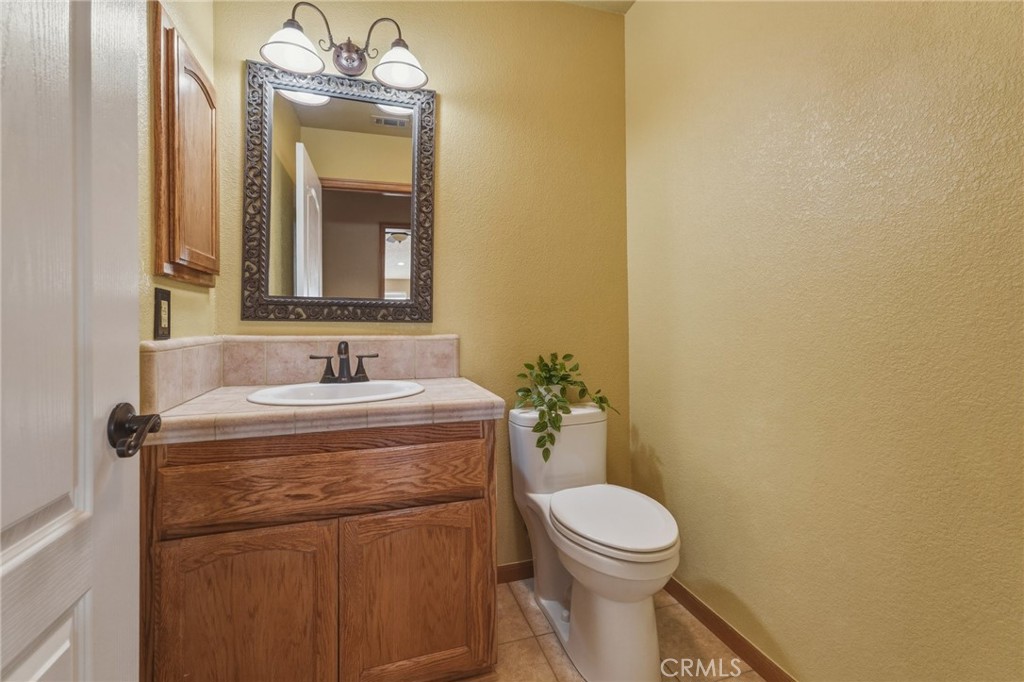19501 Kinai Road Apple Valley, CA 92307 - Photo 38 of 49 a bathroom with a granite countertop toilet sink and mirror