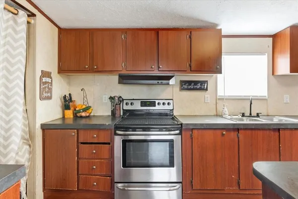 a kitchen with granite countertop wooden cabinets and stainless steel appliances