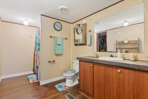 a spacious bathroom with a granite countertop sink toilet and a mirror