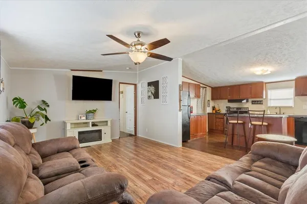 a living room with furniture kitchen view and a flat screen tv