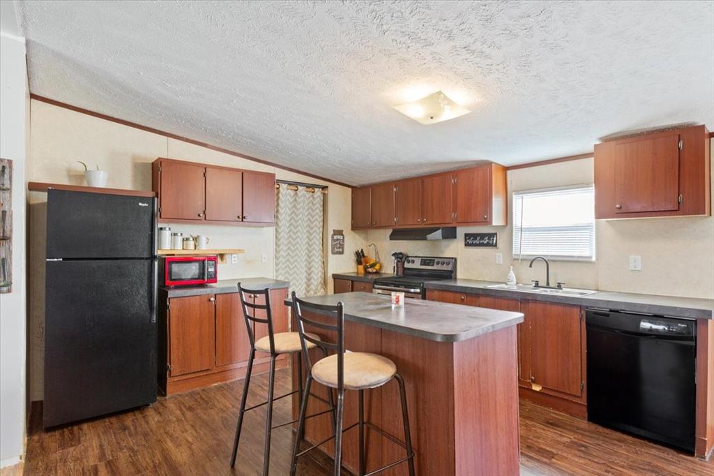 247 North Lake Street Axtell, TX 76624 - Photo 10 of 24 a kitchen with stainless steel appliances granite countertop a refrigerator a sink a stove a dining table and chairs