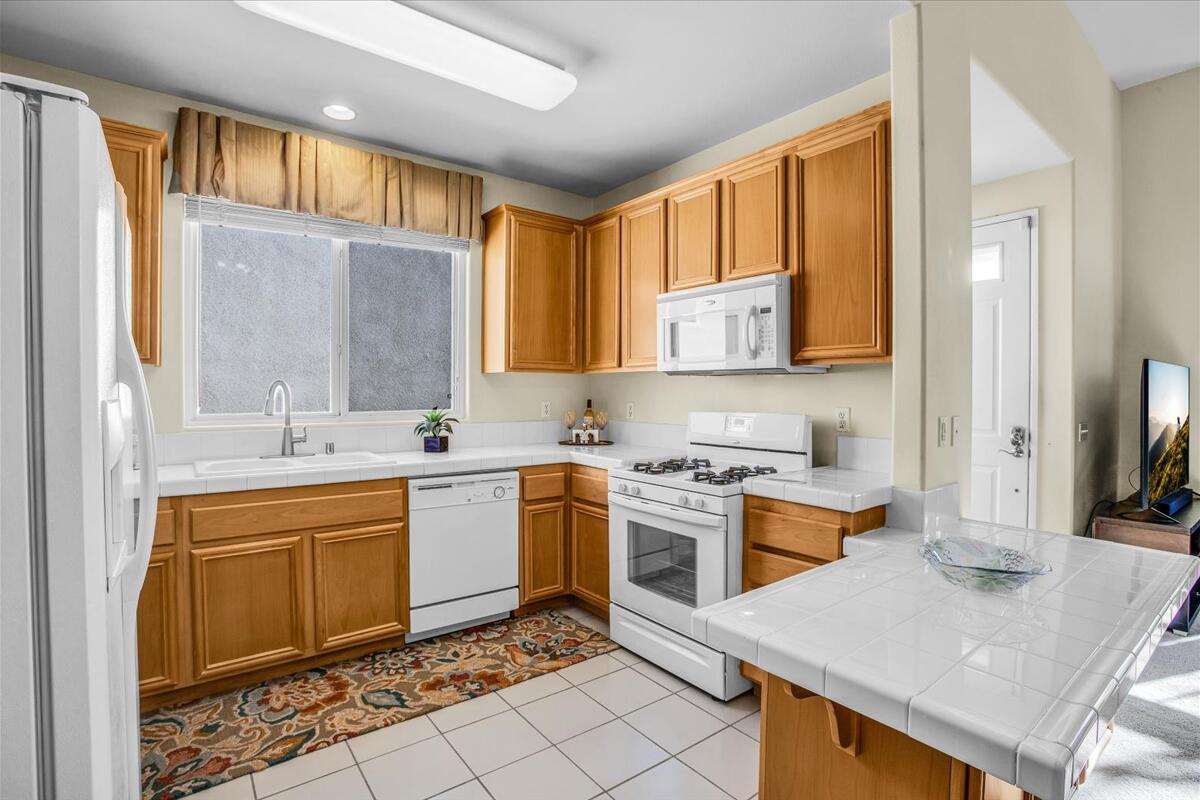 47795 Soft Moonlight La Quinta, CA 92253 - Photo 11 of 44 a kitchen with a stove a sink and a refrigerator