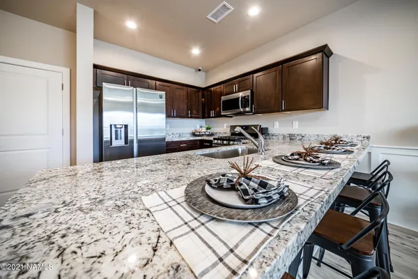 a kitchen with stainless steel appliances granite countertop a sink stove and refrigerator
