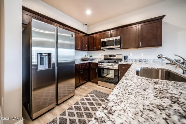 a kitchen with stainless steel appliances granite countertop a stove and a microwave