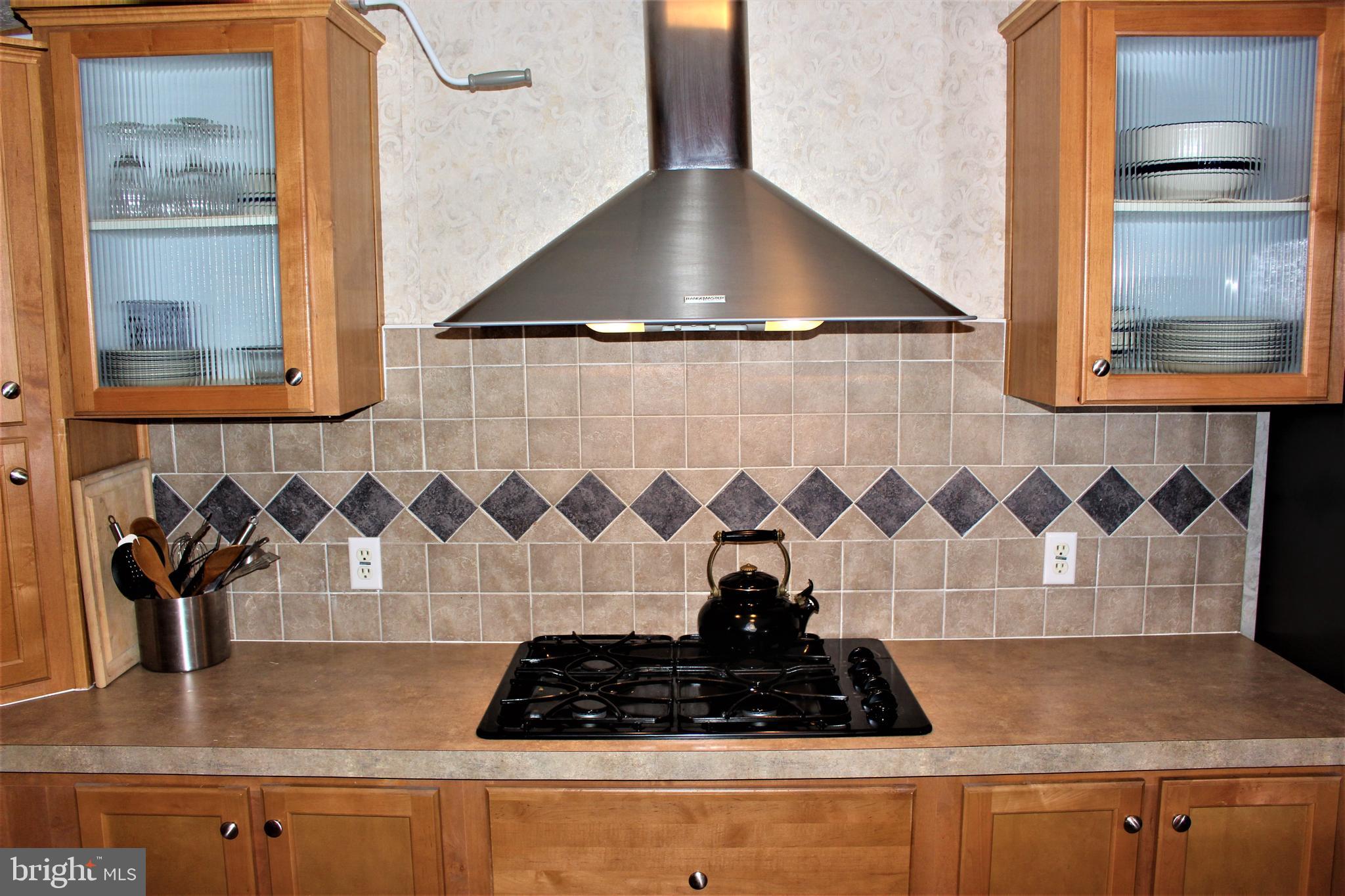 28288 Basin Road Millsboro, DE 19966 - Photo 16 of 38 Gas cooktop stove with vented hood.