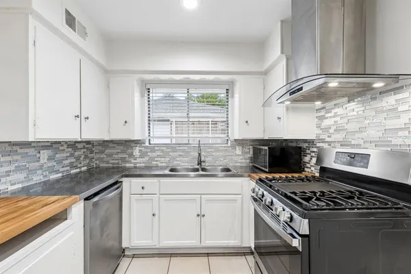 a kitchen with granite countertop a stove sink and cabinets