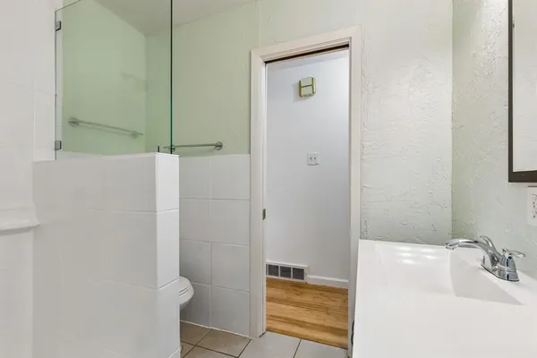 a bathroom with a sink a toilet and shower