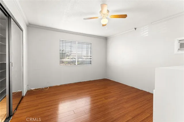 a view of an empty room with window and wooden floor