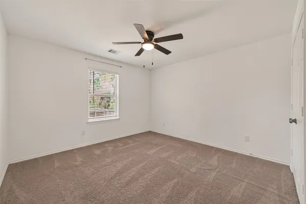 an empty room with closet and ceiling fan