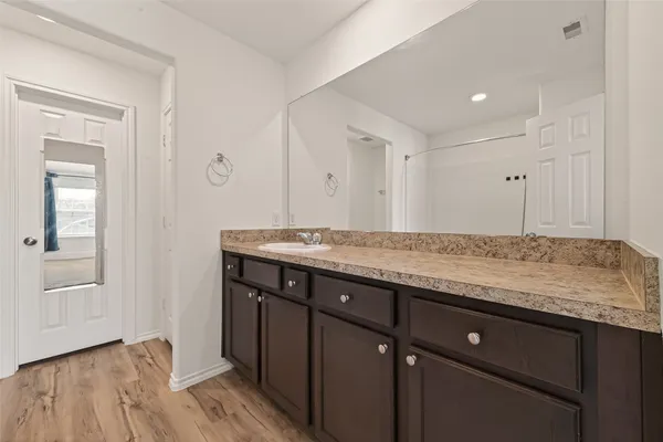 a bathroom with a granite countertop sink two mirror and a