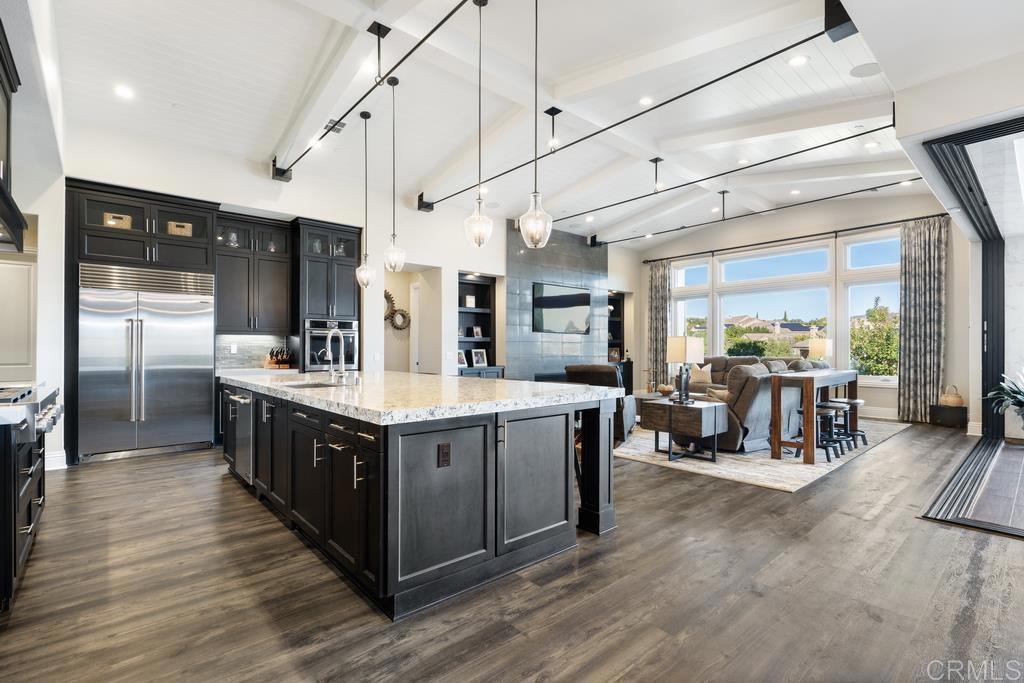 15433 Artesian Ridge San Diego, CA 92127 - Photo 2 of 20 a large kitchen with stainless steel appliances granite countertop a lot of cabinets a sink and wooden floors