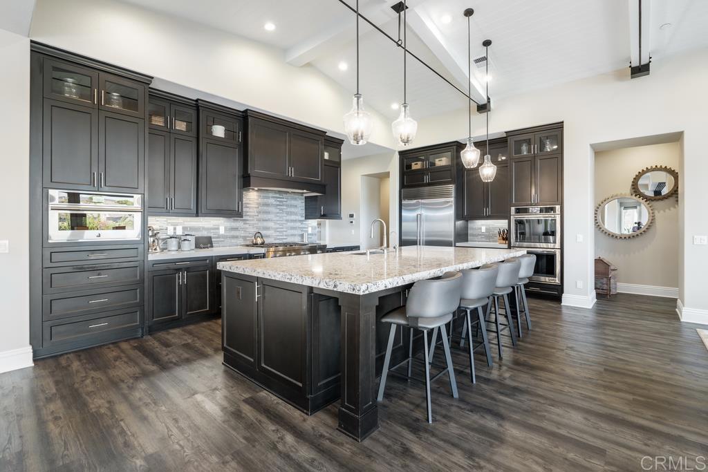 15433 Artesian Ridge San Diego, CA 92127 - Photo 4 of 20 a kitchen with kitchen island granite countertop wooden floors and stainless steel appliances