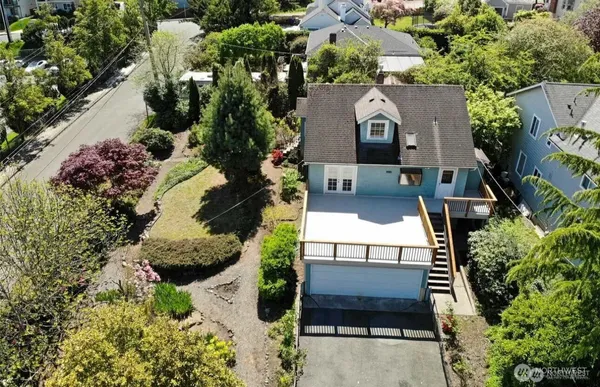 an aerial view of a house with a yard and large trees