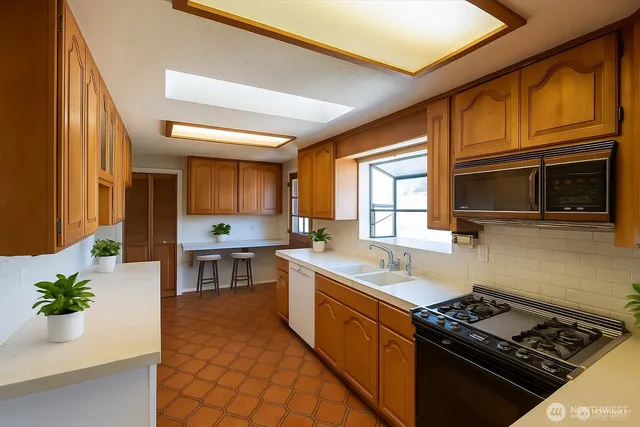 a kitchen with stainless steel appliances granite countertop a stove a sink and a microwave