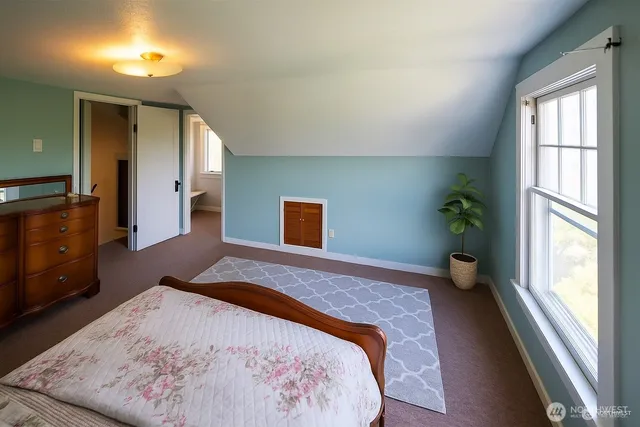 a bedroom with a bed and a large window