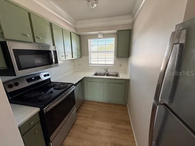 a kitchen with stainless steel appliances a stove a sink and a refrigerator