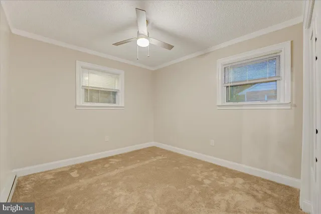 a view of an empty room with a chandelier fan