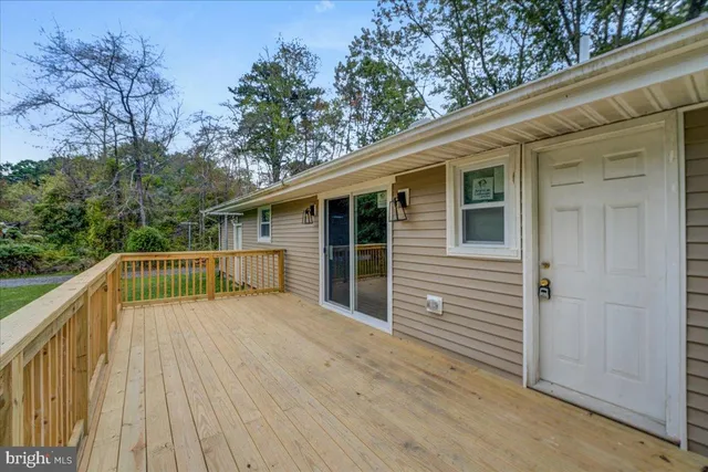 a view of deck with wooden floor and fence next to a yard