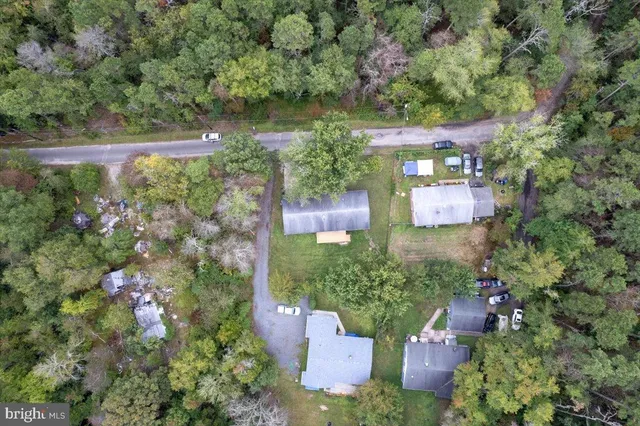 an aerial view of residential house with outdoor space and trees all around