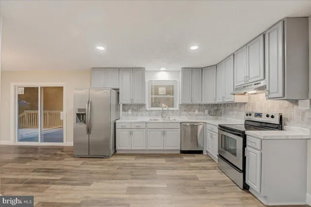 a kitchen with stainless steel appliances granite countertop a refrigerator sink and cabinets