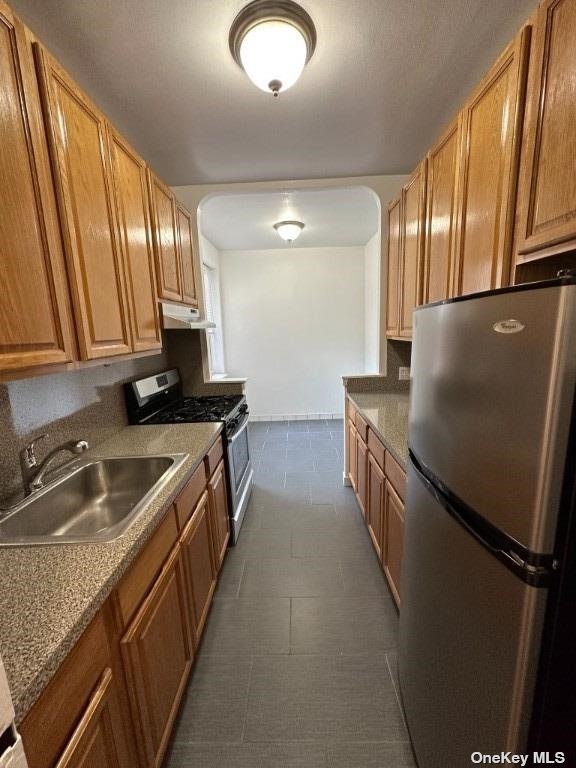 a kitchen with stainless steel appliances granite countertop a refrigerator a stove a sink and a microwave