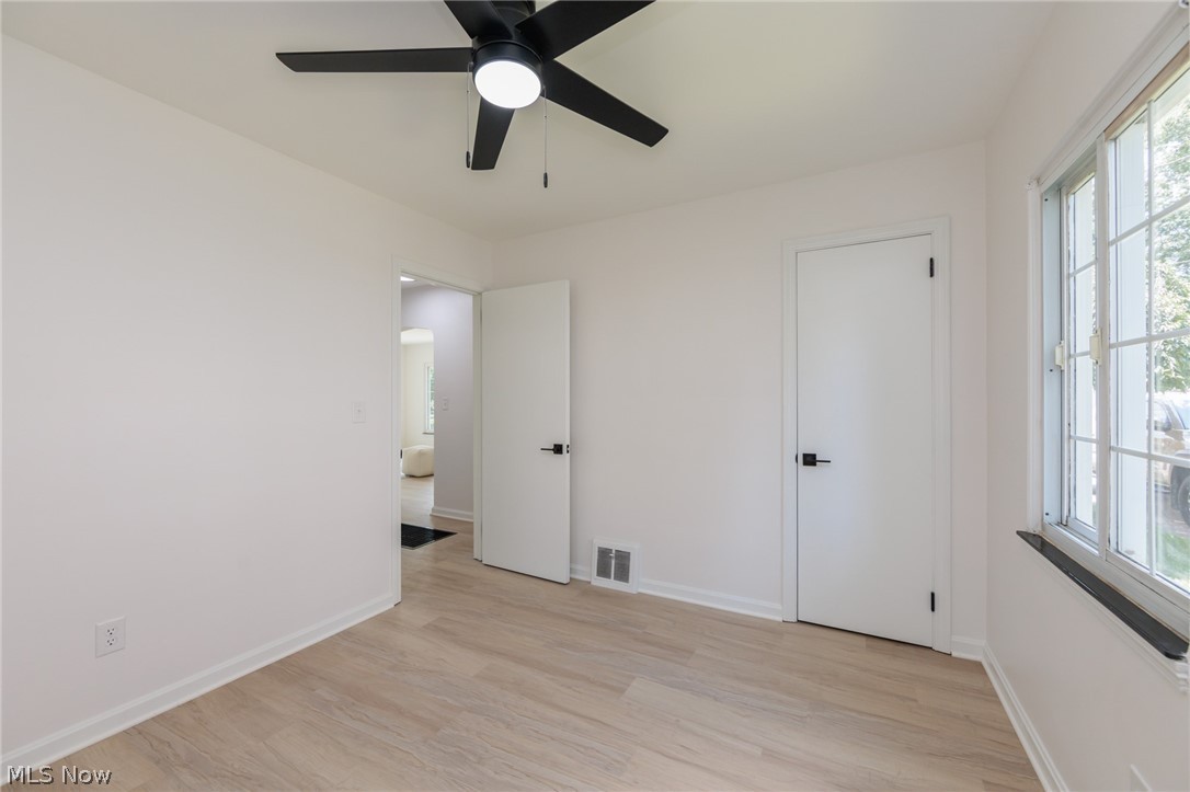 173 Wichita Place Akron, OH 44313 - Photo 22 of 32 Room featuring light wood-finish flooring, a contemporary black ceiling fan with integrated lighting, and white walls with baseboard trim