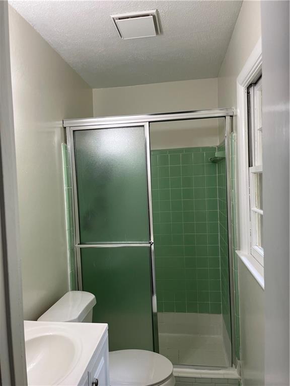 1432 Spring Valley Lane Lilburn, GA 30047 - Photo 7 of 11 a bathroom with a shower a toilet and a sink
