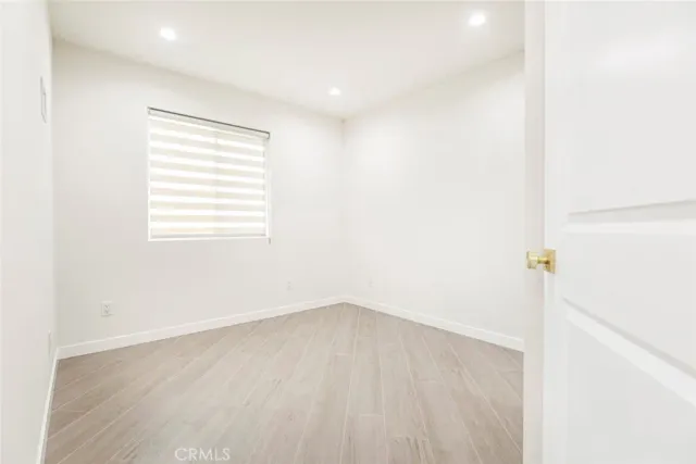 a view of a room with wooden floor and a window
