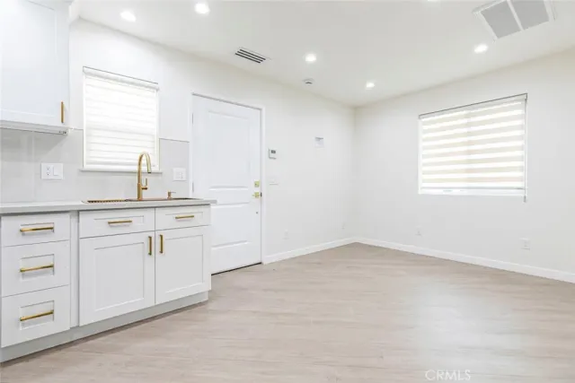 a kitchen with white cabinets and sink