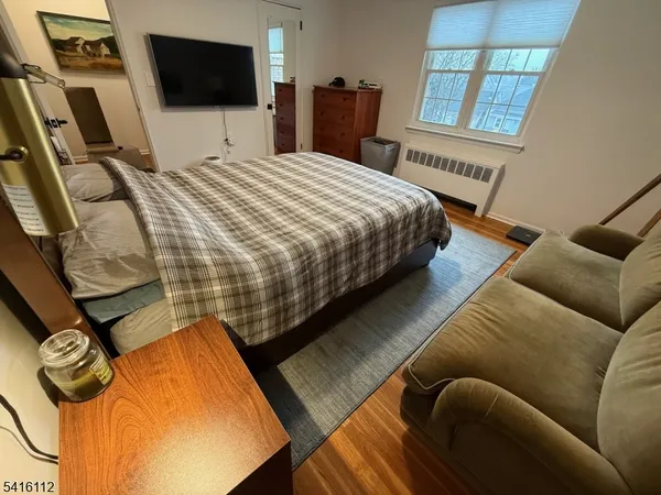 a bedroom with a bed a flat screen tv and a window