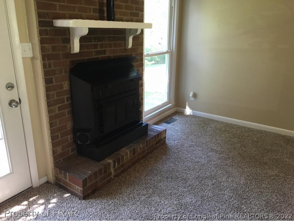 3320 Red Fox Road Spring Lake, NC 28390 - Photo 4 of 19 a view of an empty room with wooden floor and a fireplace