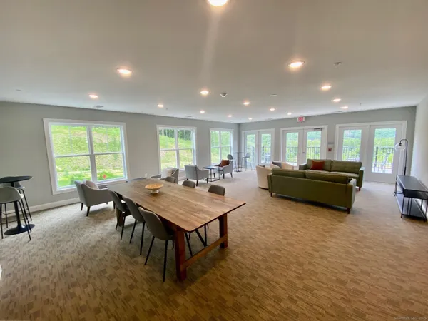 a living room with furniture a large window and a table