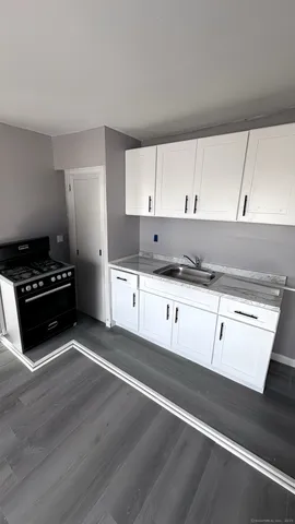 a kitchen with granite countertop a stove a sink and a microwave