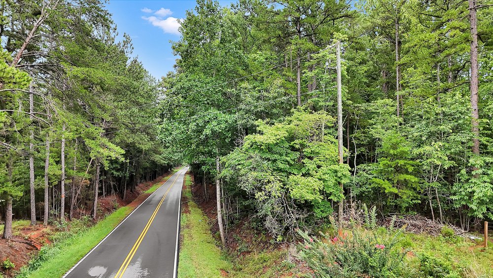 5 State Rd S-4-97 Anderson, SC 29621 - Photo 2 of 15 A tranquil, tree-lined road invites peaceful journeys through nature's embrace.