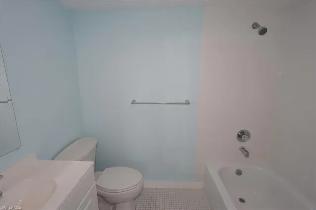 a white toilet sitting next to a bath tub