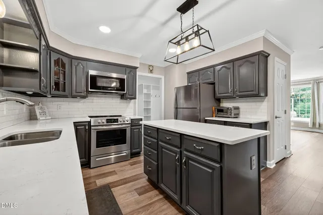 a kitchen with stainless steel appliances granite countertop a refrigerator stove and sink