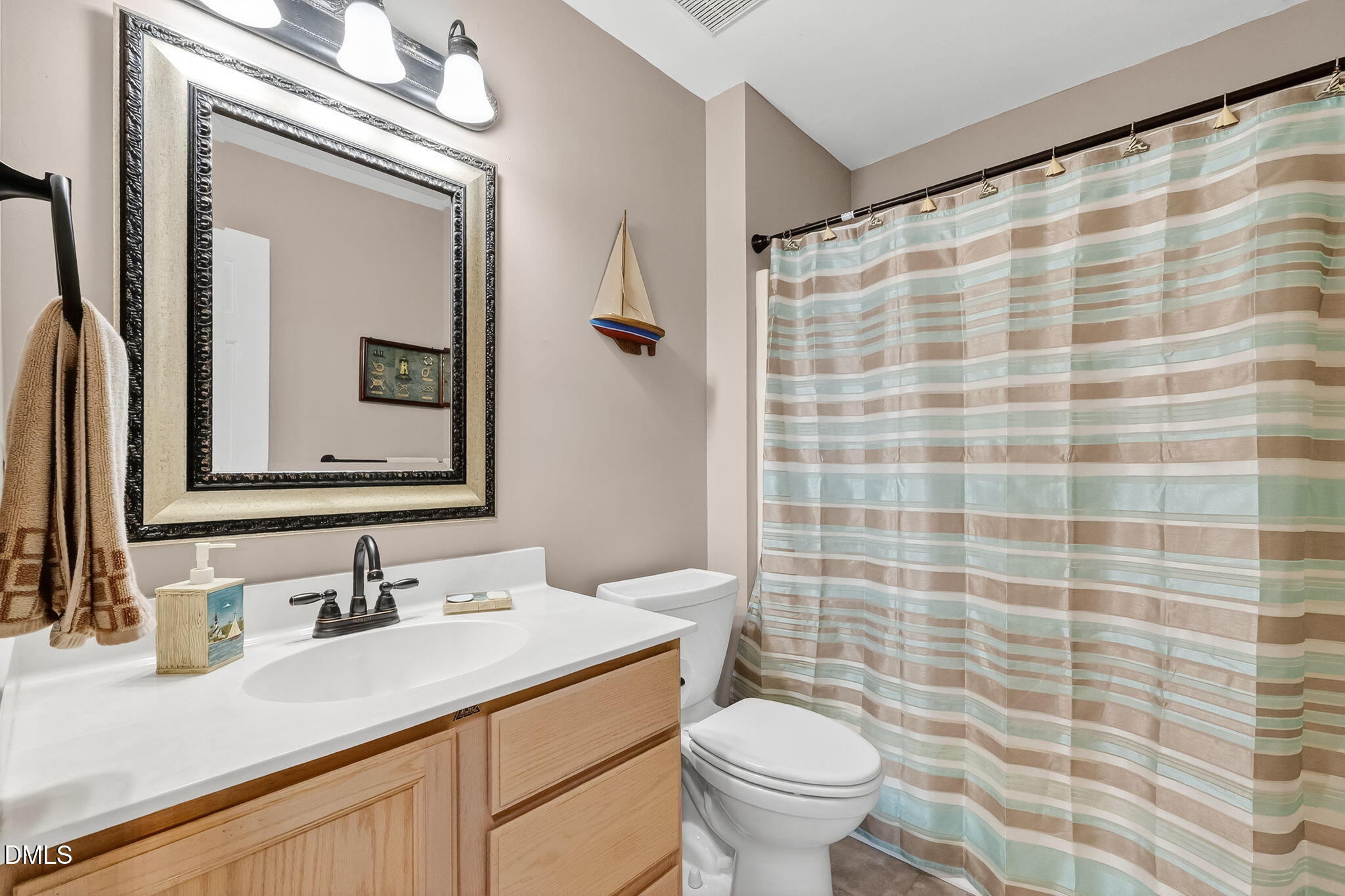 6009 Swales Way Raleigh, NC 27603 - Photo 39 of 59 a bathroom with a granite countertop sink toilet a mirror and shower curtain