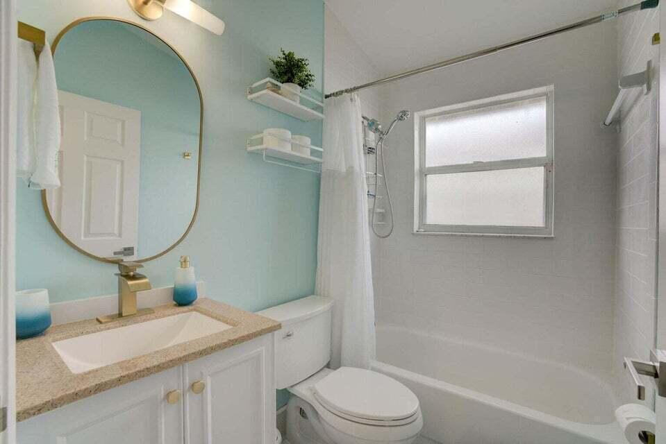6178 Garrett Street Jupiter, FL 33458 - Photo 13 of 18 a bathroom with a granite countertop sink mirror toilet and bathtub