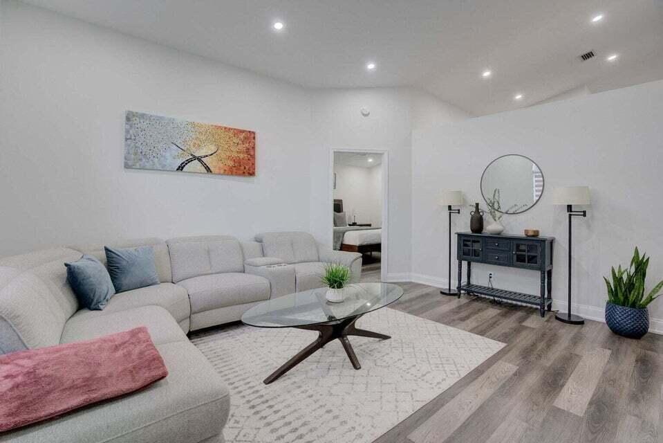 6178 Garrett Street Jupiter, FL 33458 - Photo 3 of 18 a living room with furniture a rug and a potted plant