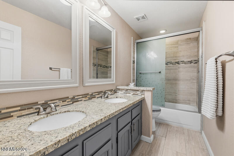 675 College Drive Reno, NV 89503 - Photo 24 of 30 a bathroom with a granite countertop sink mirror and shower