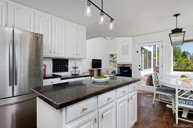 a kitchen with stainless steel appliances granite countertop a stove refrigerator and cabinets
