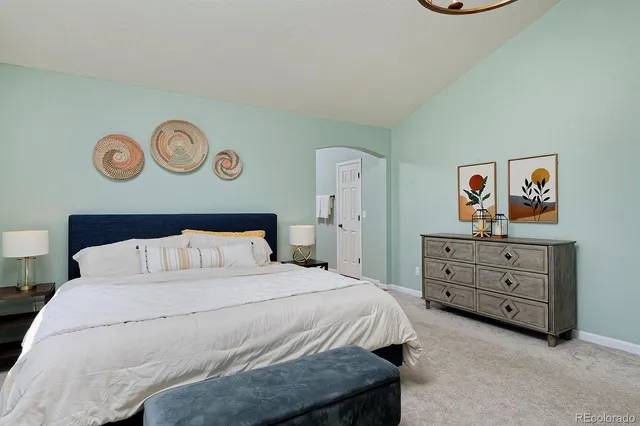 a bedroom with a bed and painting on the wall