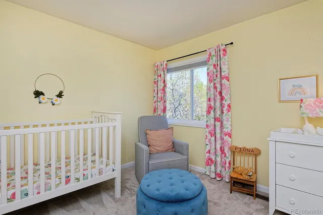 a bedroom with a baby bed a couch and dresser